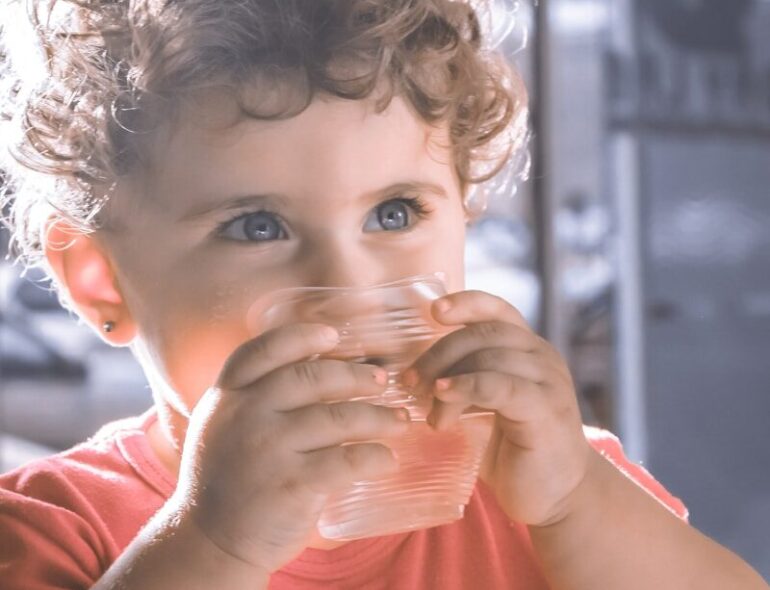 a child drinking from a glass